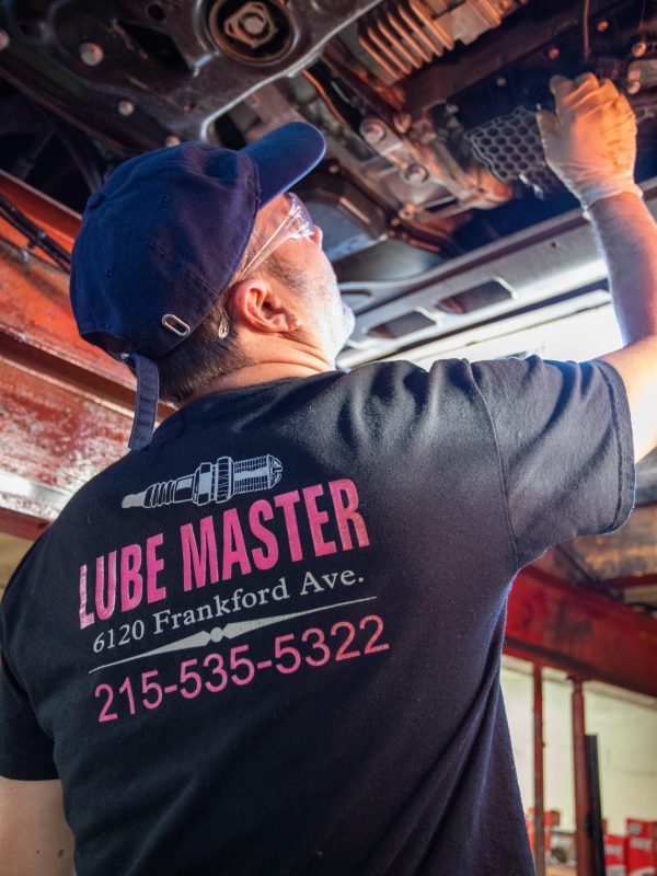 Lube Master employee examining the bottom of a vehicle.