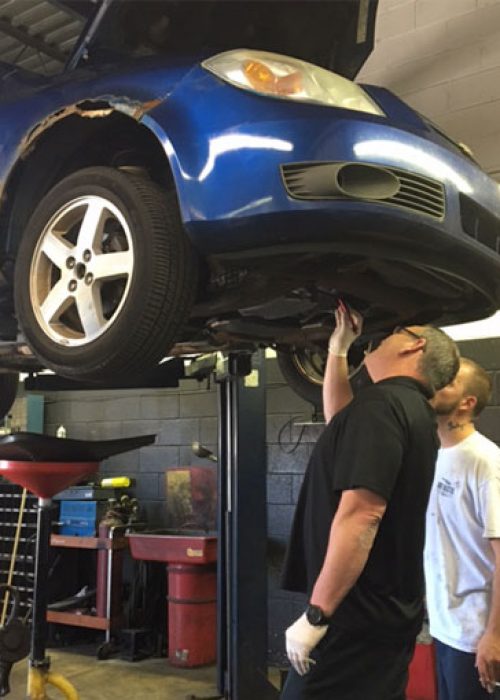 Two team members performing a service on a car.